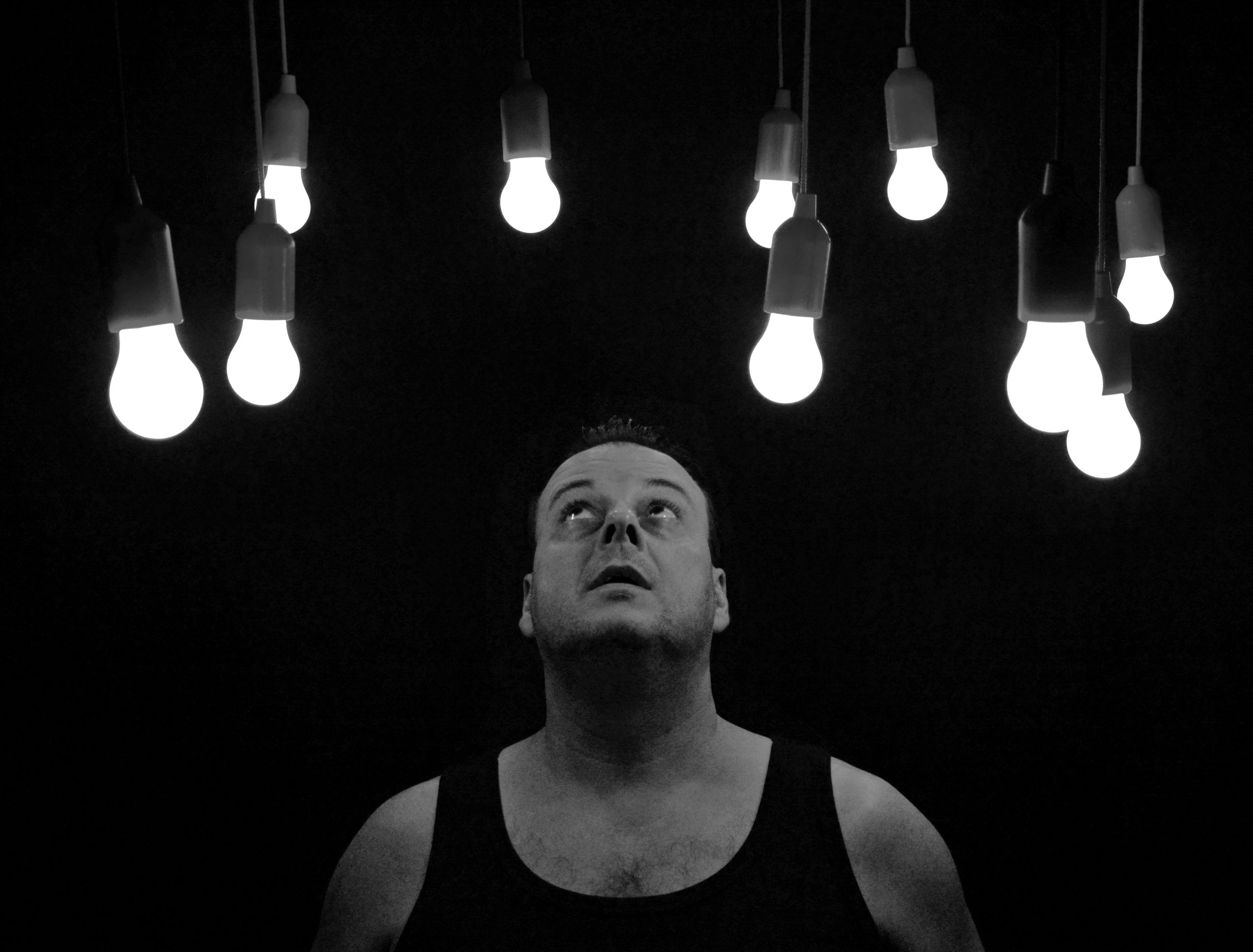 Male looking up at multiple LED bulbs.