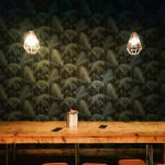 can on table near turned on lamp sconces