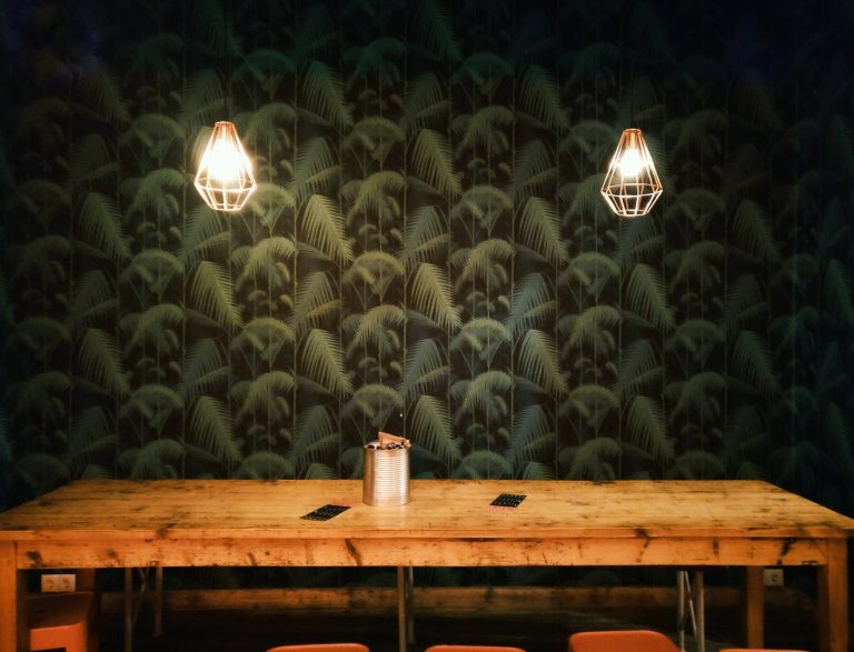 can on table near turned on lamp sconces