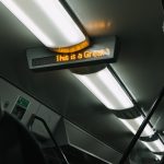 modern lights and electronic scoreboard on ceiling of subway car