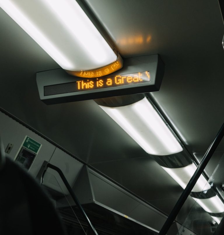 modern lights and electronic scoreboard on ceiling of subway car